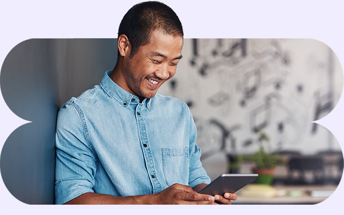 Man smiling while working on a tablet