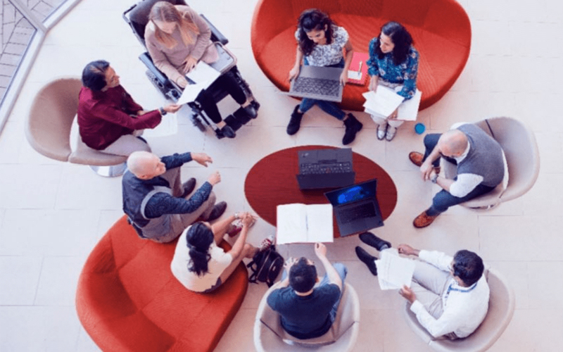 People sat around a table using Lenovo laptops