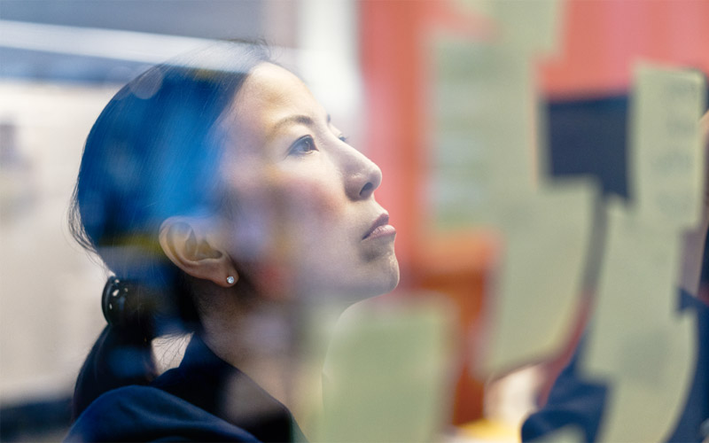 Woman using stick notes on window