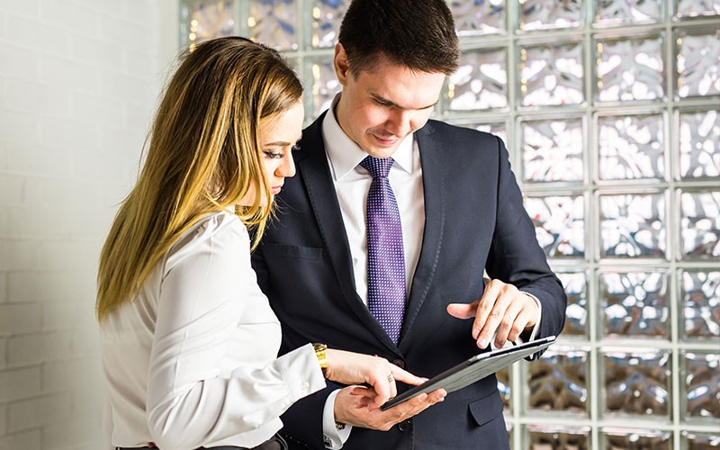 Integrate Mac into your organisation’s enterprise identity management system Two colleagues looking at an iPad