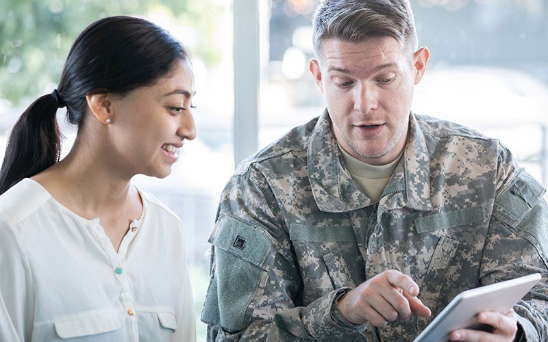Governement An army personnel interacting with a civilian using an apple device