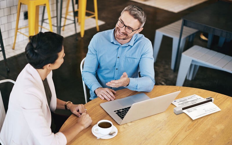 Epson scanner on desk with two users talking