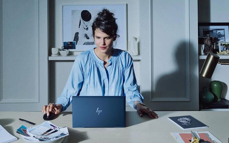 Hp Wolf Security Woman sat at desk HP laptop device