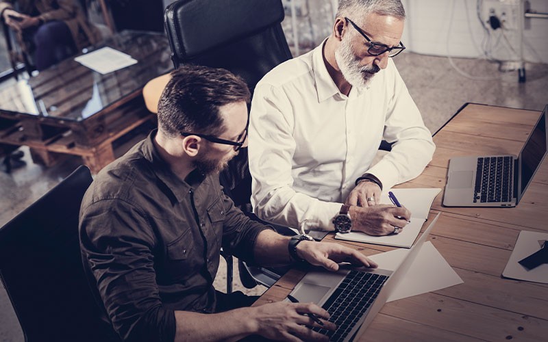 Two men working on a laptop