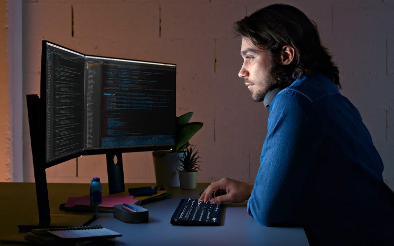 The key to mastering a big project. Man using MX Keys keyboard at night.