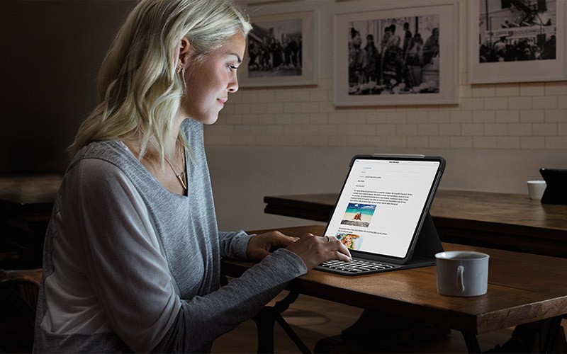 Enjoy laptop-like typing on your iPad Woman working on an iPad at night.