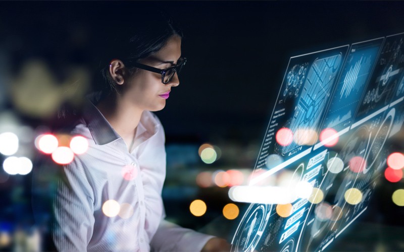 woman with laptop surrounded by binary code