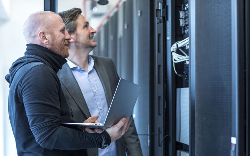Improve performance and receive automated alerts Two men working in a data centre