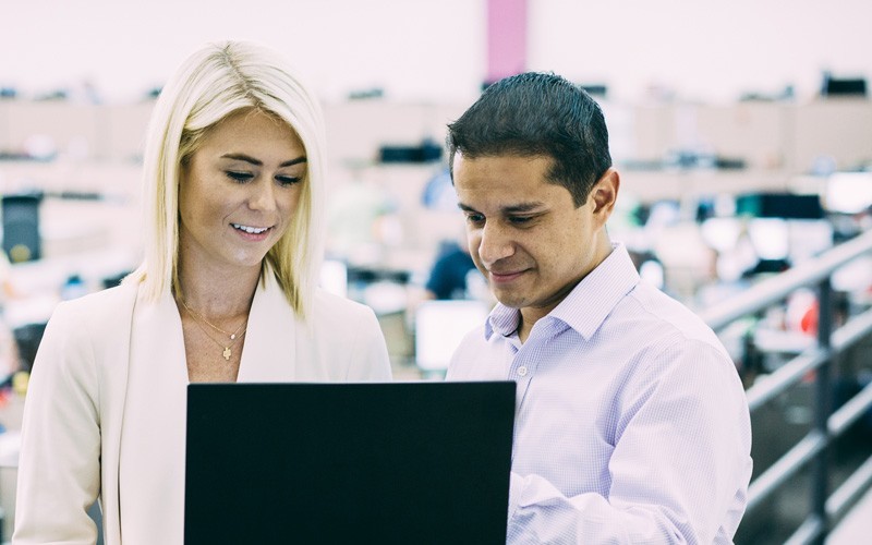 Oracle Managed Cloud Services Business professional reviewing information on notebook computer with with IT admin