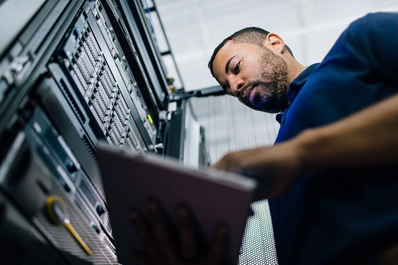 Enterprise-level cloud services IT admin reviewing data center information on tablet computer