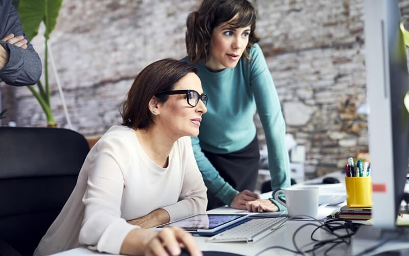 Simplify your security policies Two businesswomen on desktop computer