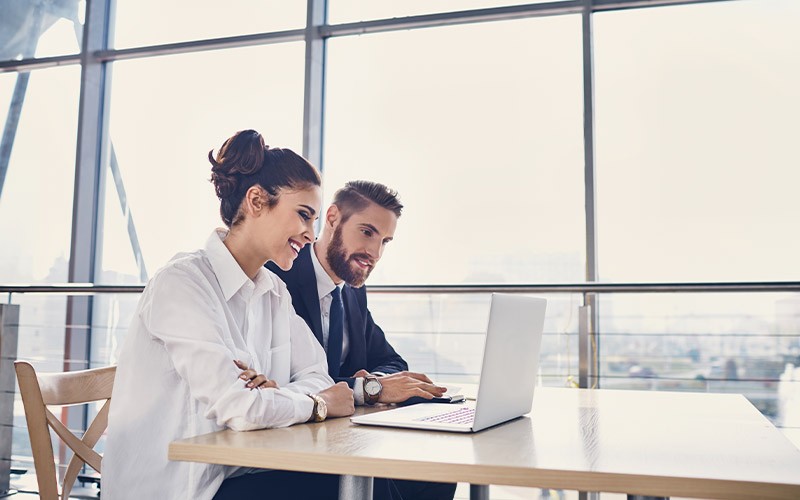 Two colleagues working together on a laptop