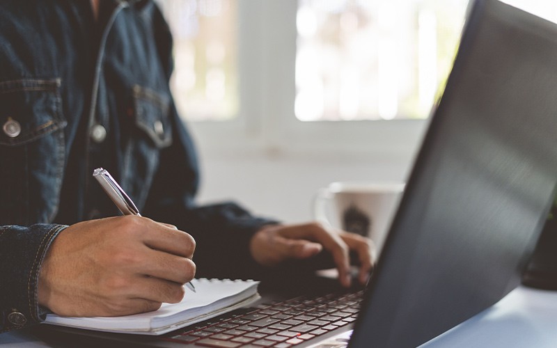 Stop ransomware in it's tracks Man taking notes from a laptop device