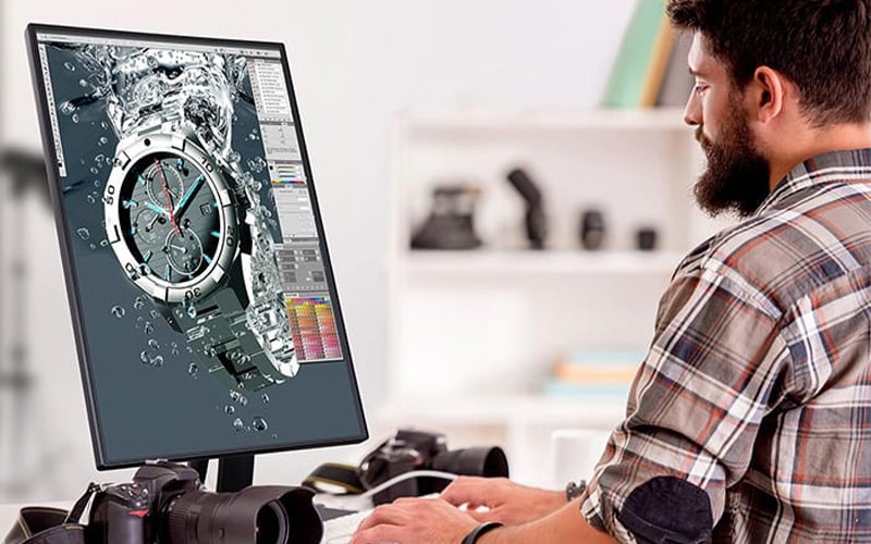 Photographer editing photos on a Viewsonic monitor