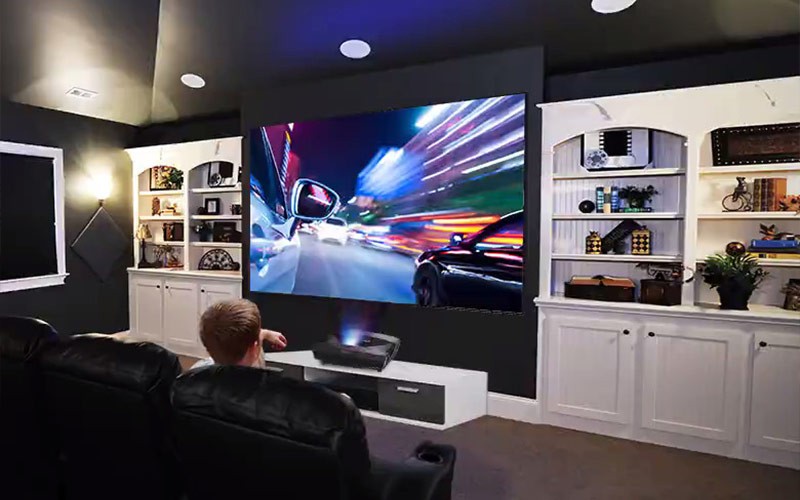 Man sitting on a sofa in front of a Viewsonic projector
