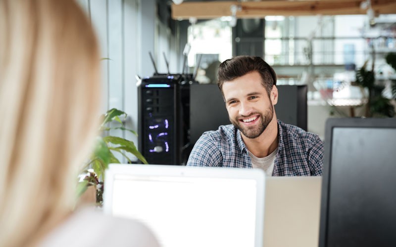 Hybrid clouds and native public clouds Employee smiling at desk